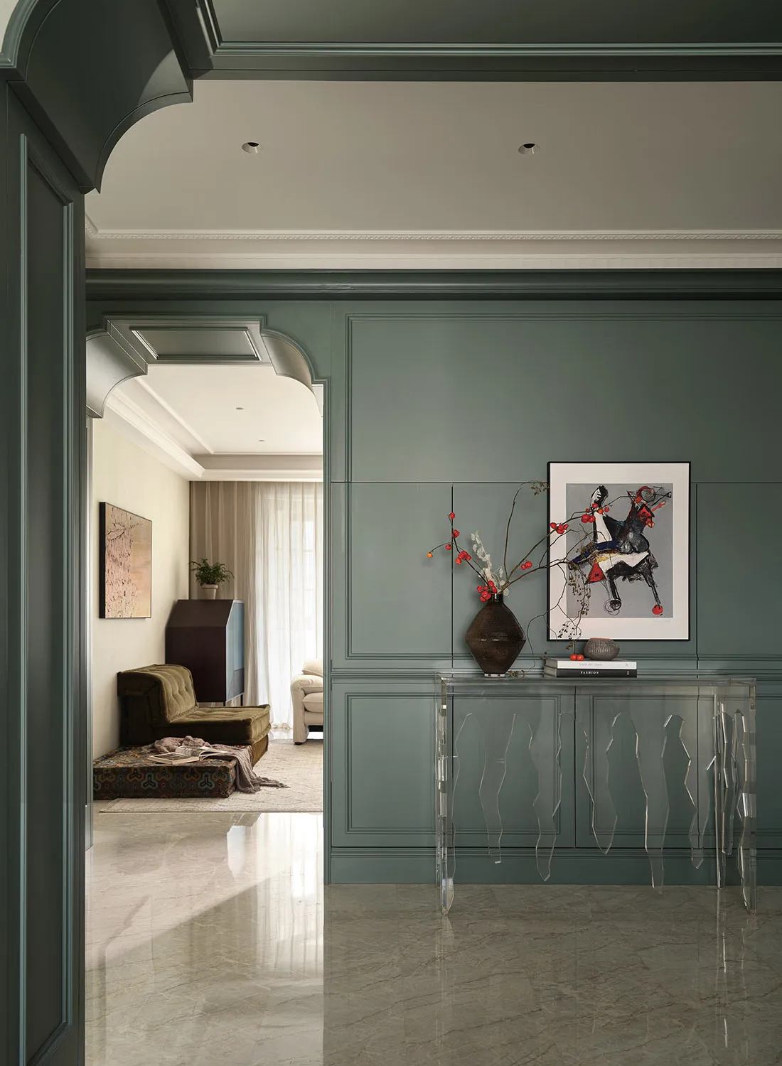 Glass console table with a vase containing red berries in a modern living room.