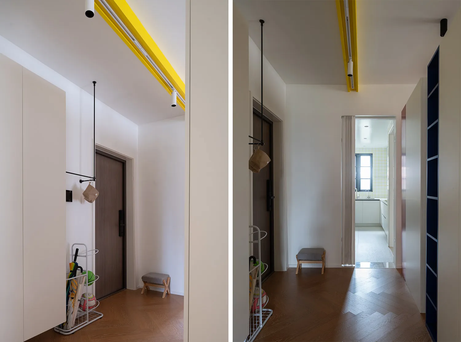 A minimalist interior with hardwood floors, showing a corridor with yellow lighting and a view into a kitchen area.