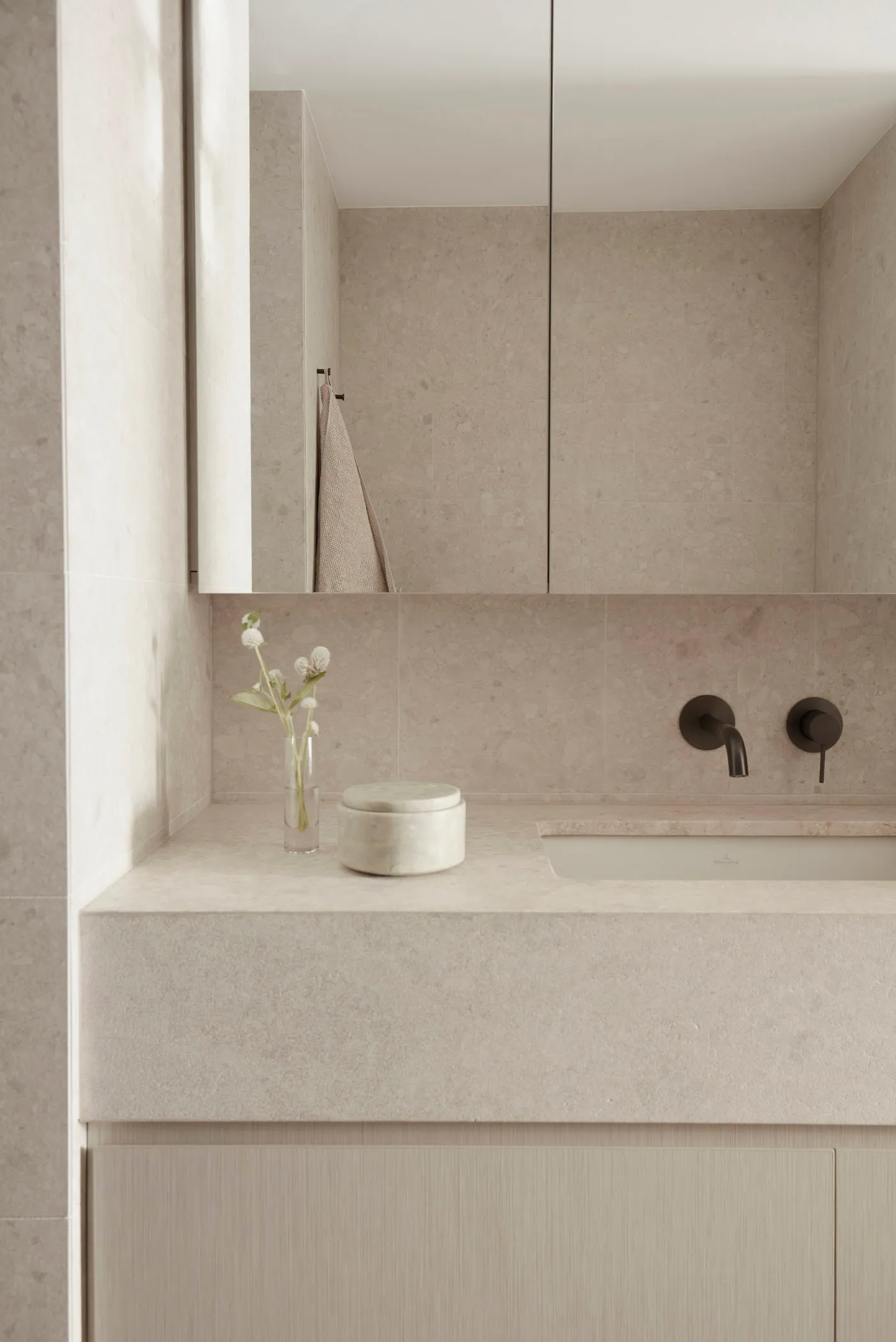 Modern bathroom with concrete tile walls, a sleek floating vanity, and minimalist design.