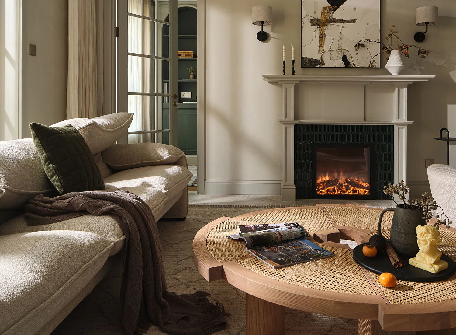 A modern living room featuring a rattan table, comfortable seating, and a cozy fireplace.
