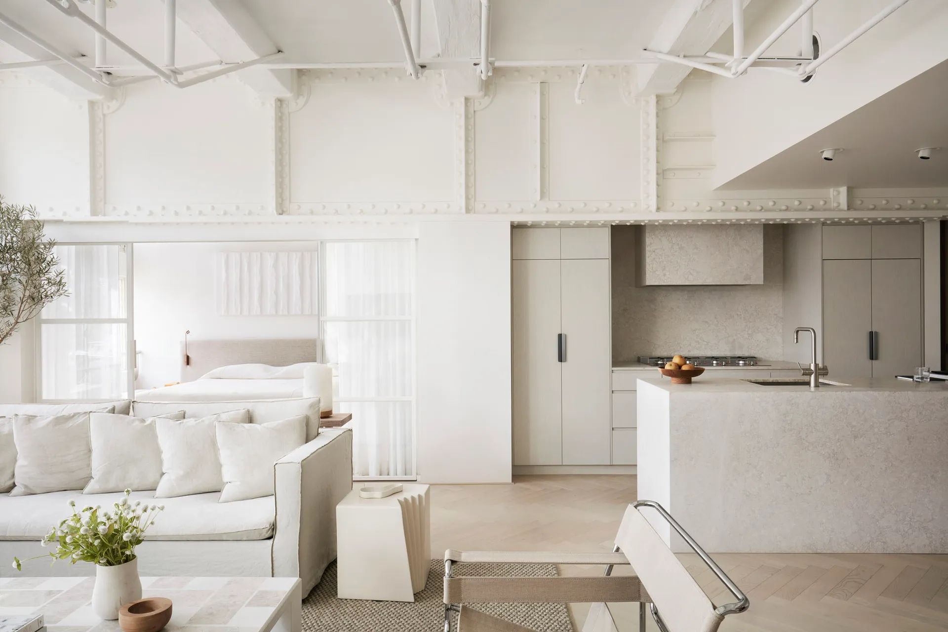 A minimalist living space with all white decor and furniture