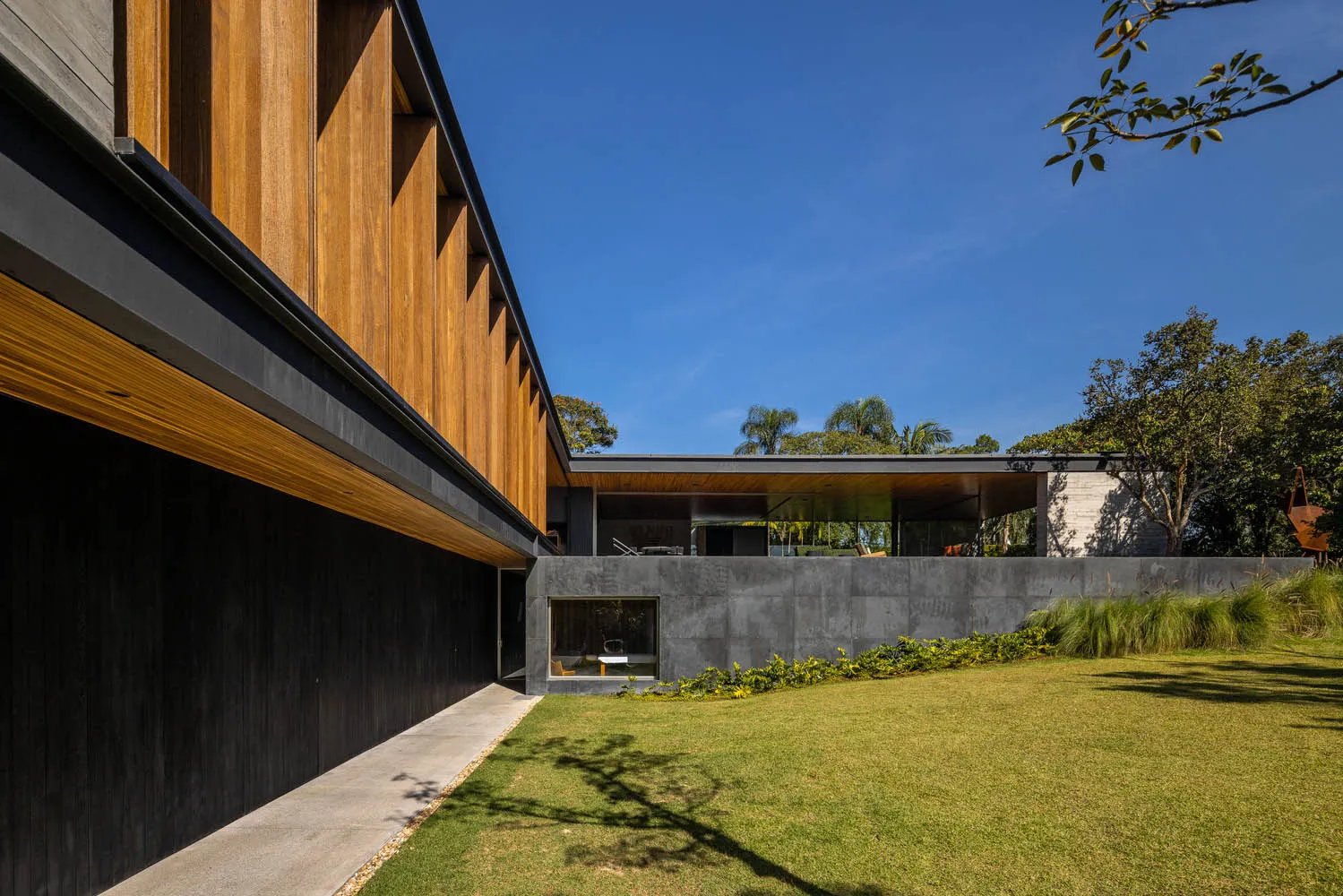 Modern residential building exterior with wooden panels and concrete walls.