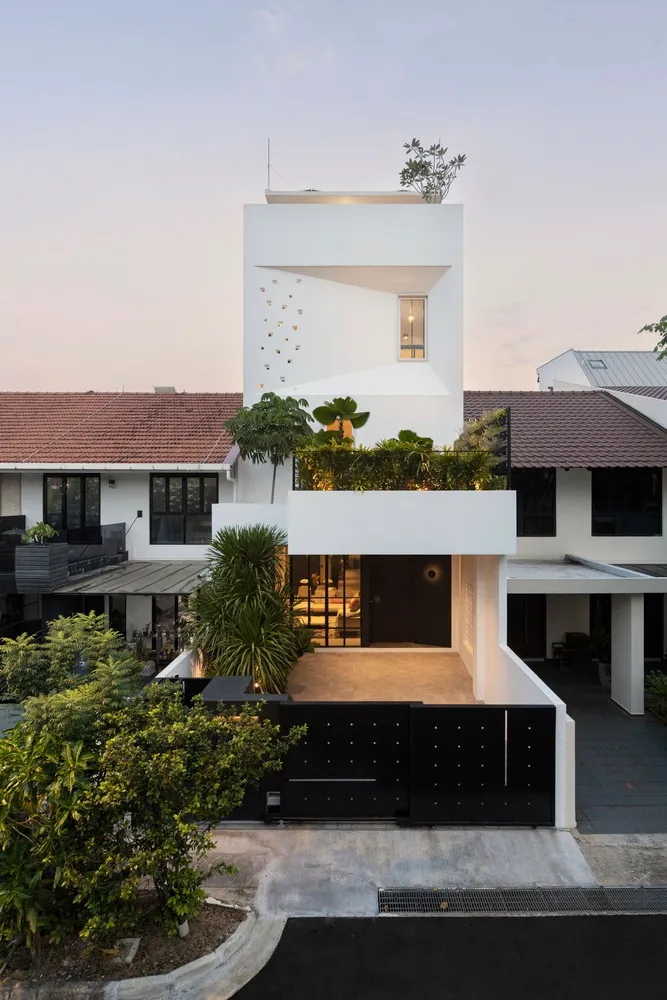 White-rendered exterior of a modern house with a garden.