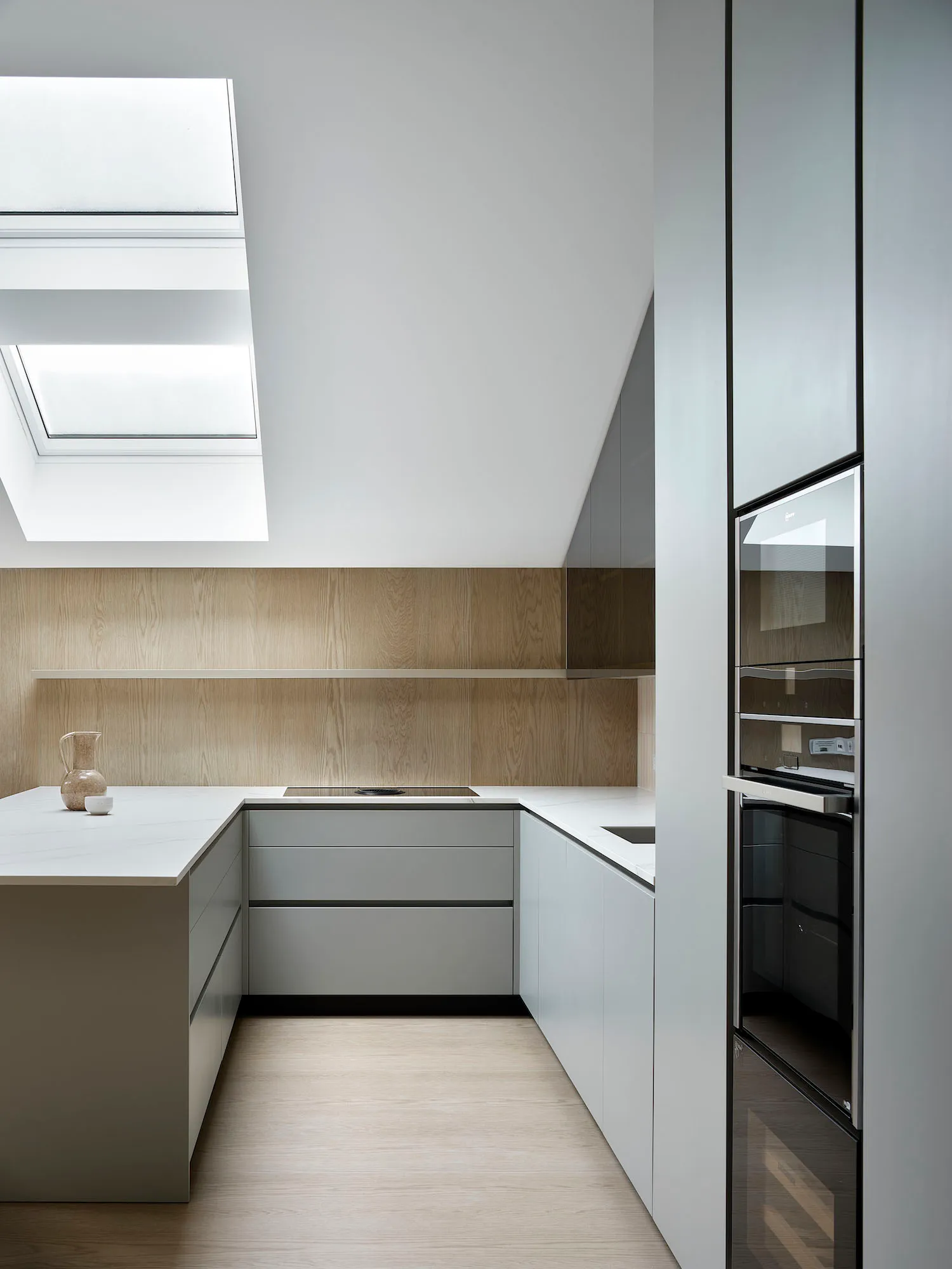 A modern kitchen with white marble countertops and stainless steel appliances.