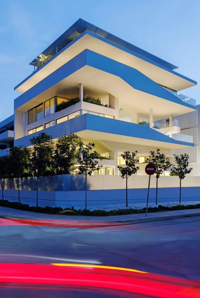 一座以混凝土與玻璃材質建造的現代公寓大樓。