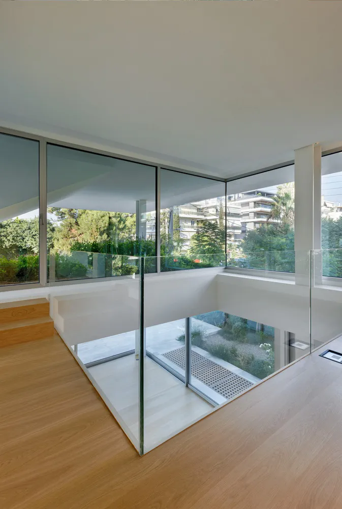 Modern architectural design featuring a glass staircase with wood flooring.