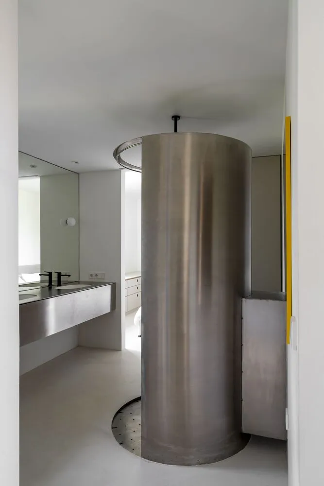 A minimalist bathroom with a stainless steel tower