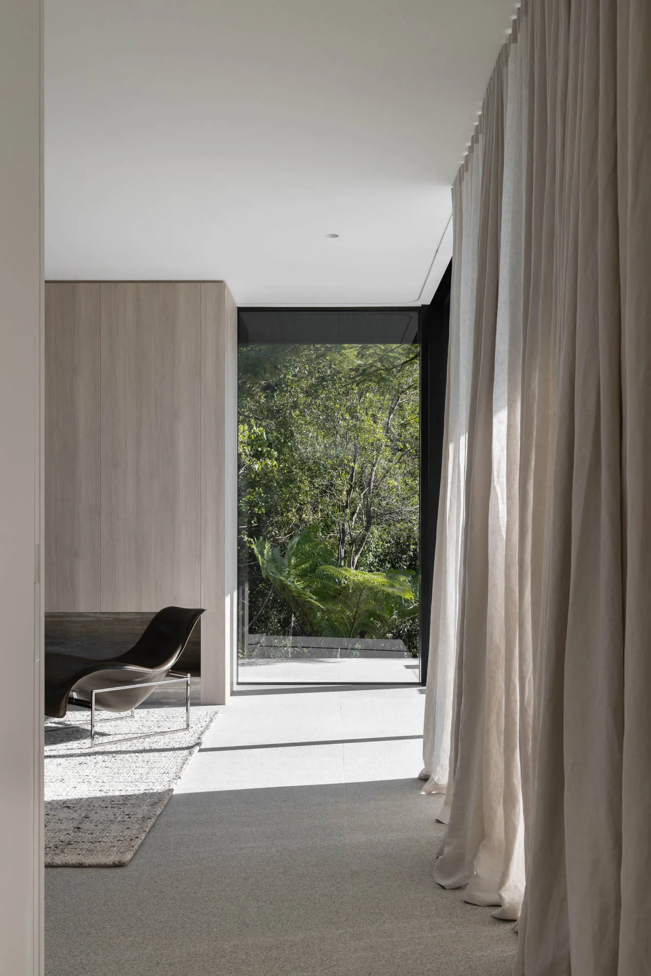 Modern architectural windows overlooking a lush forest