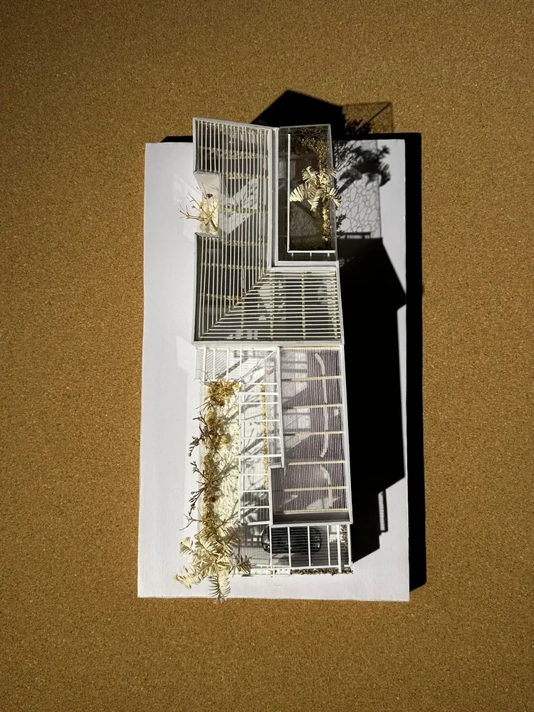 Scale model of a modern building with metal roofing and structural features.