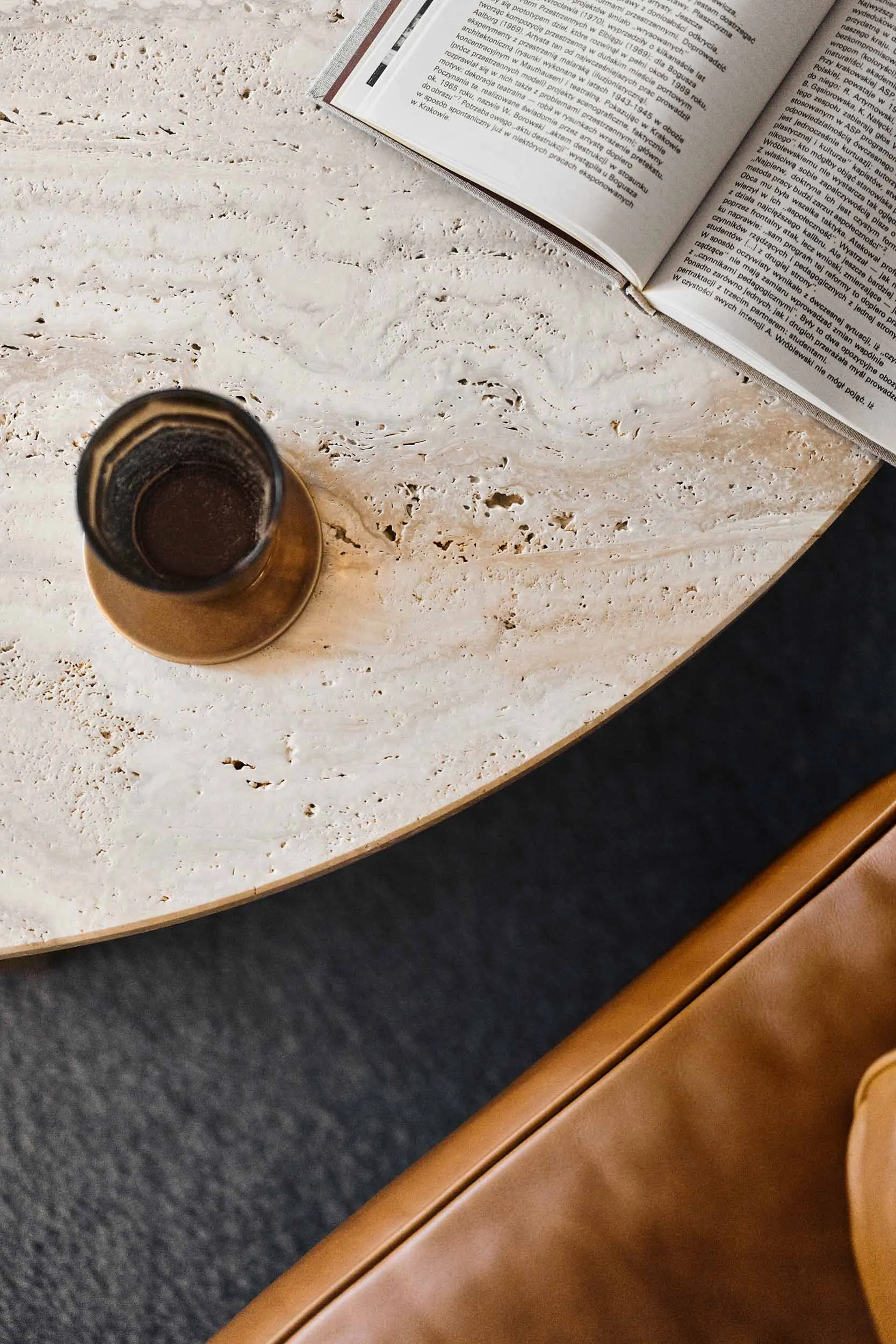 A modern coffee table setting featuring marble and a book on a table.