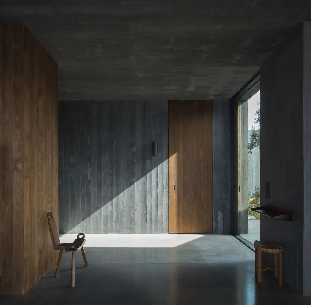 Modern entryway featuring wooden and concrete materials.