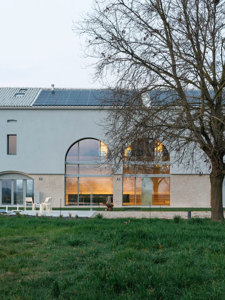 A modern house exterior featuring large glass windows