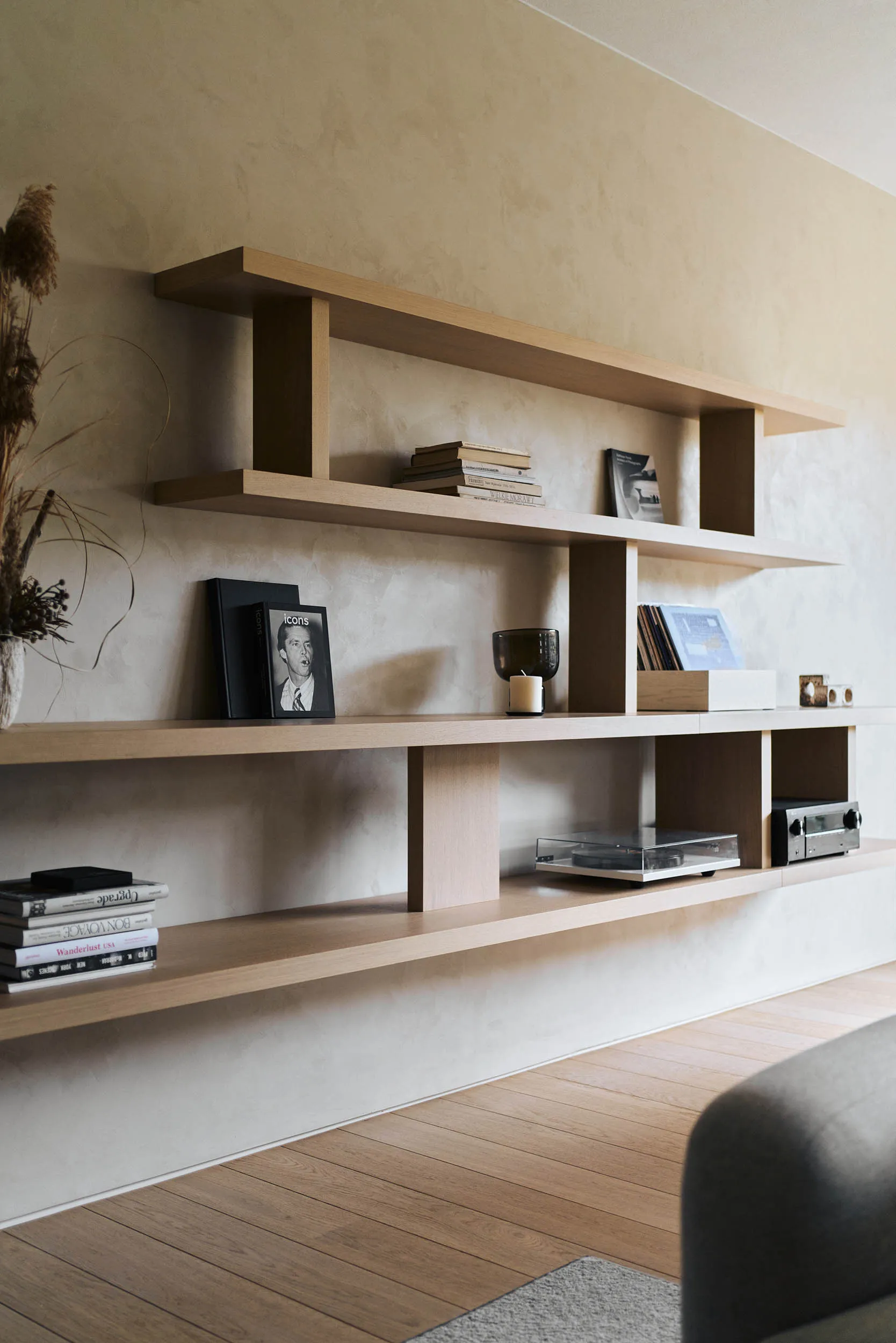 A modern minimalist living room featuring wooden shelves.