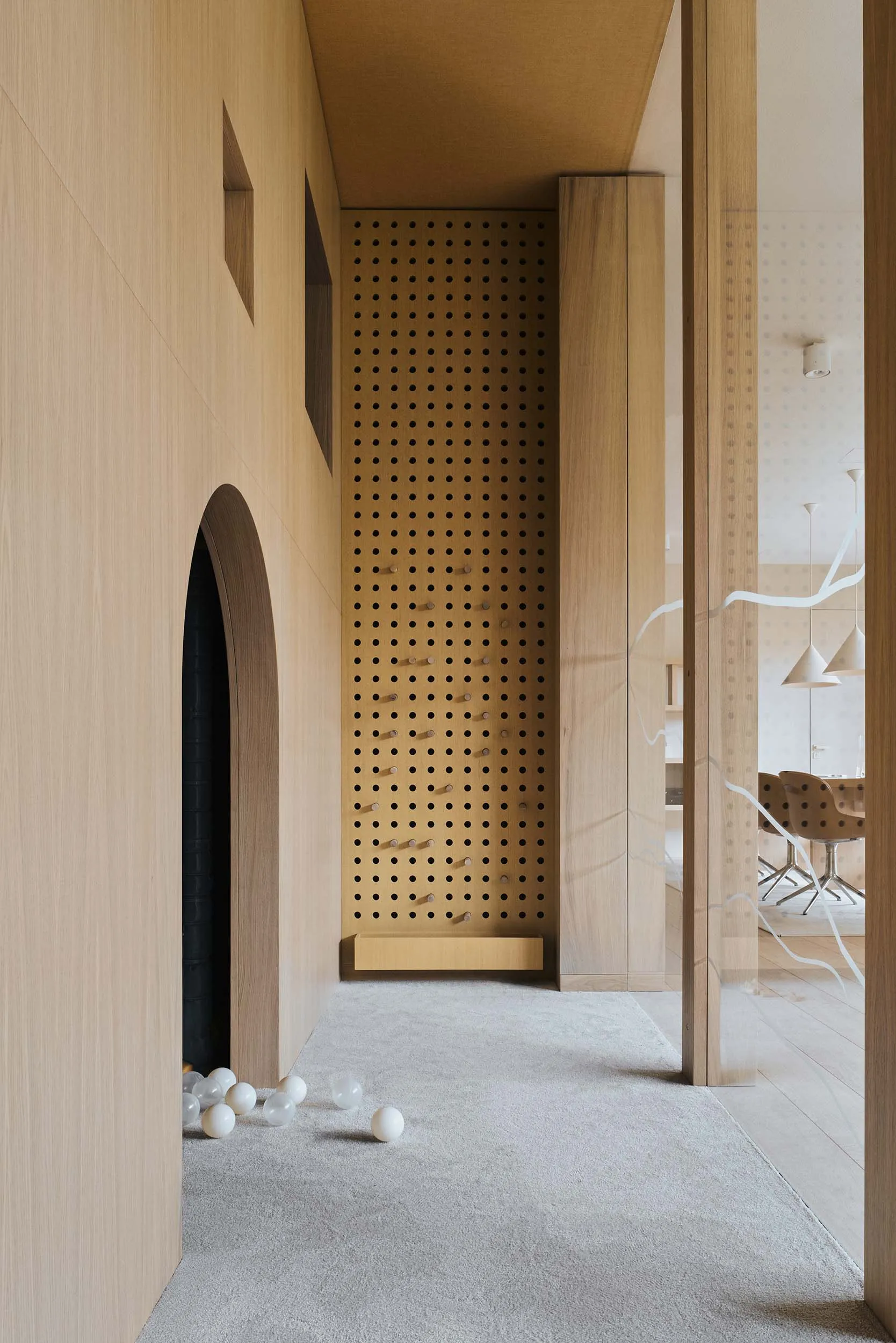 A modern playroom featuring wooden walls and a ball pit with white balls
