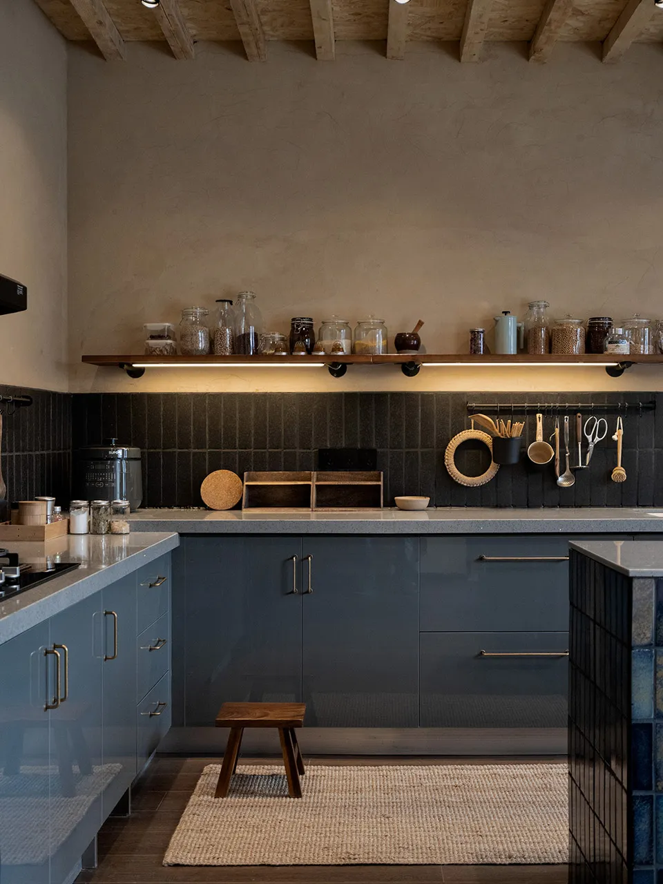 Industrial-style kitchen featuring glass, plaster, and wooden elements.