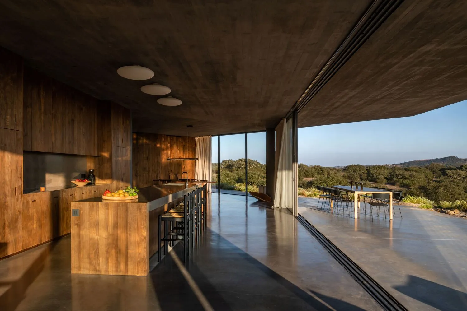 A modern residential kitchen with concrete and wooden elements