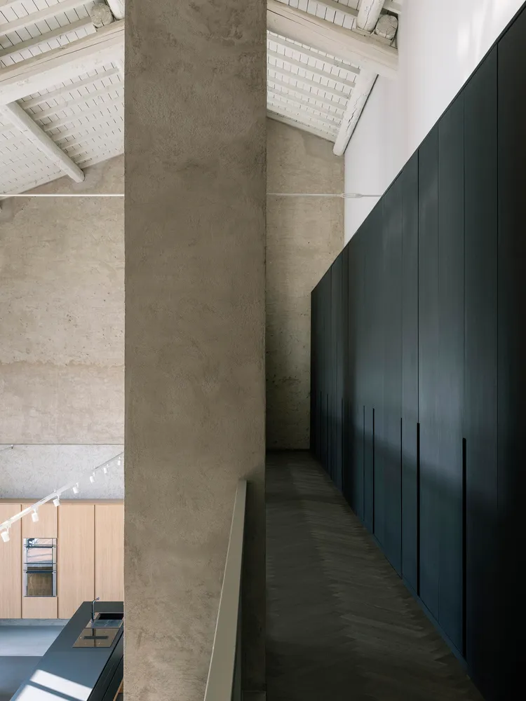 A modern, minimalist architectural interior featuring exposed concrete walls and flooring.