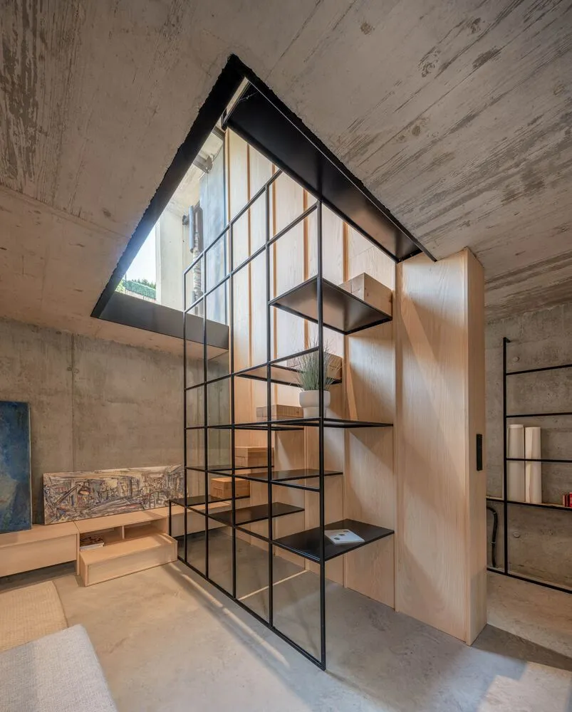 A modern living space featuring concrete, light-wood, and glass materials.