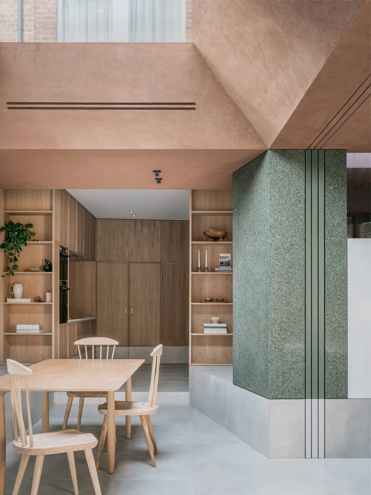 Modern minimalist kitchen featuring wood furniture, concrete countertops, and terrazzo flooring.