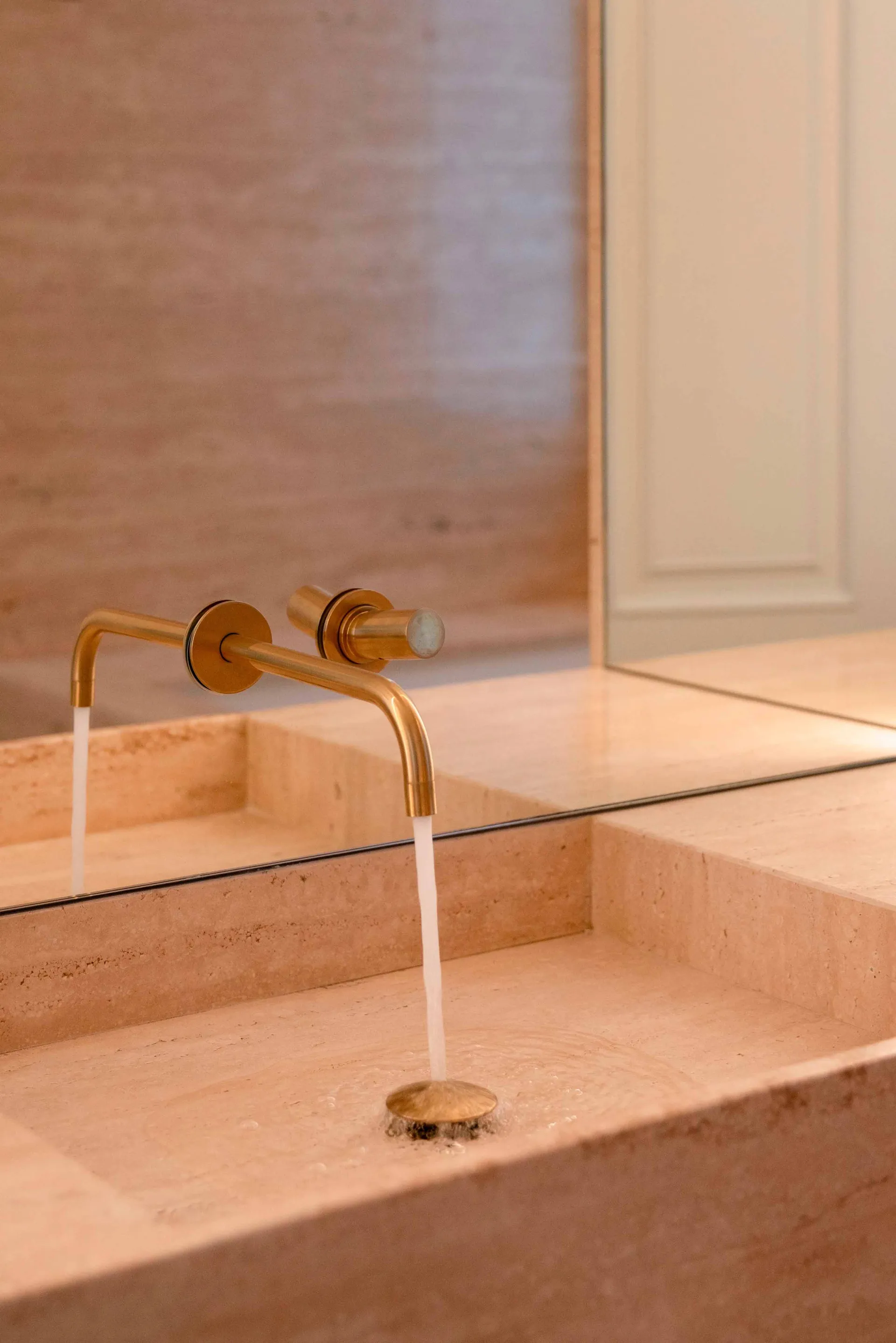 Minimalist bathroom with brass faucet and marble sink