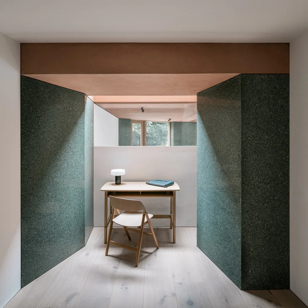 Modern office space featuring a desk, chair, and lamp with minimalist design elements.
