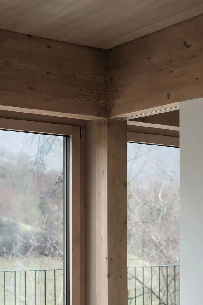 Modern interior design featuring wooden framed windows with a natural outdoor view.