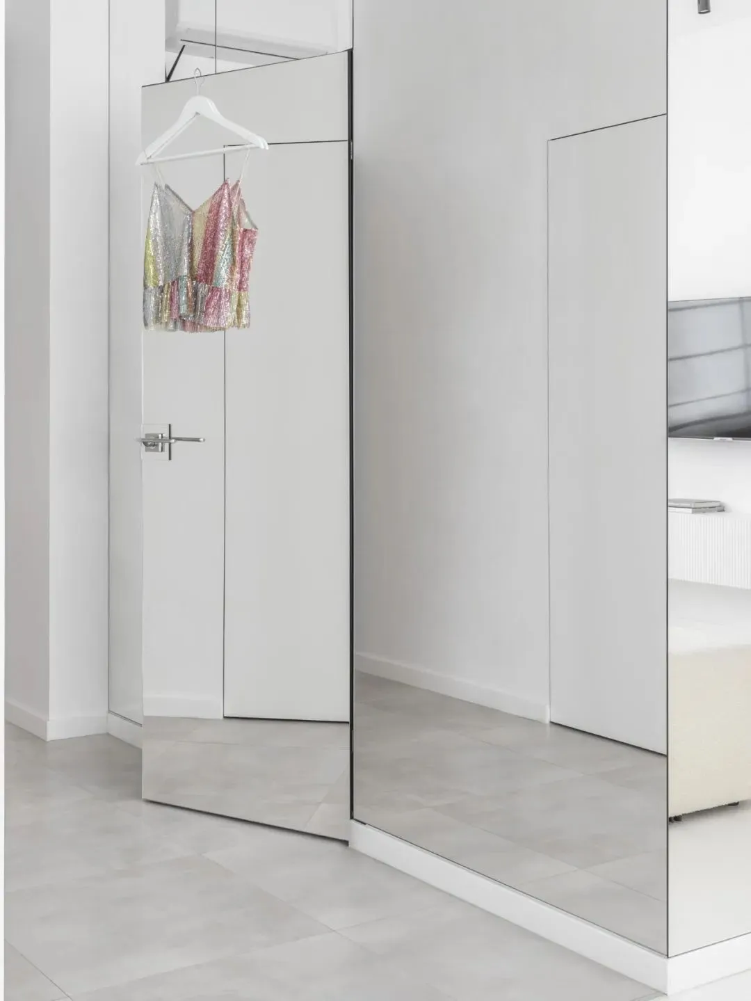 A minimalist wardrobe with mirrored glass doors.