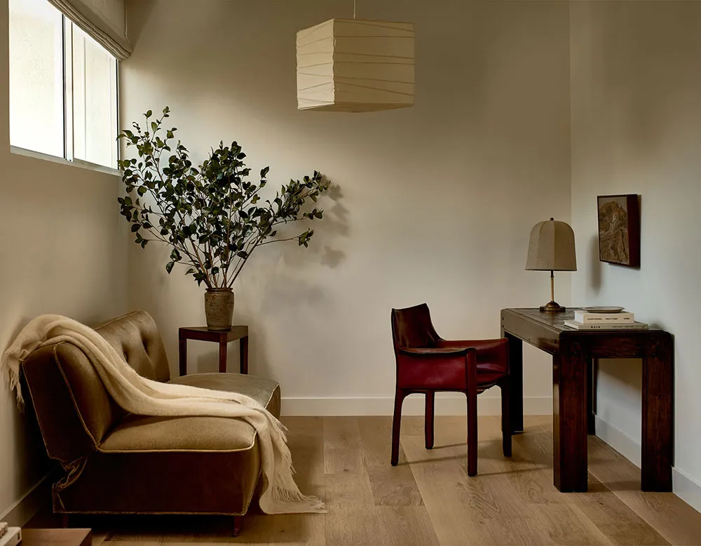 A modern living room featuring wooden furniture, fabric sofa, and leather chairs.