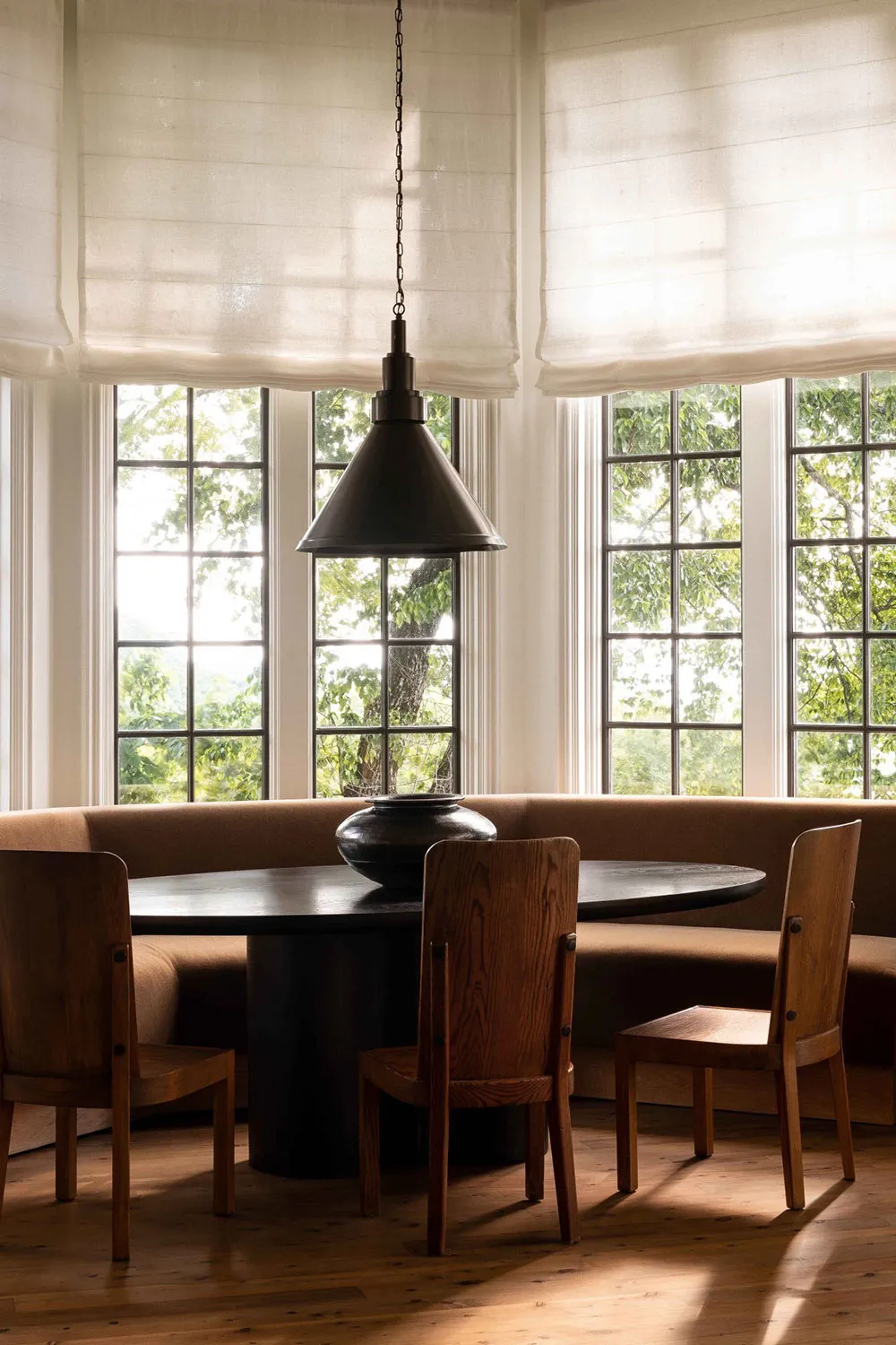 Modern living-dining-kitchen area with wooden and metallic furniture, marble countertop, and large windows.