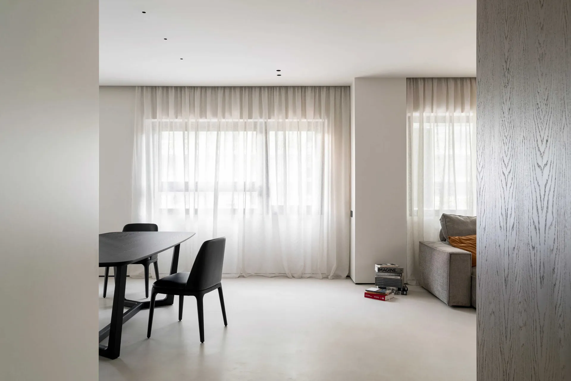 A modern minimalist living room featuring a textured white cloth for the furniture and curtains.
