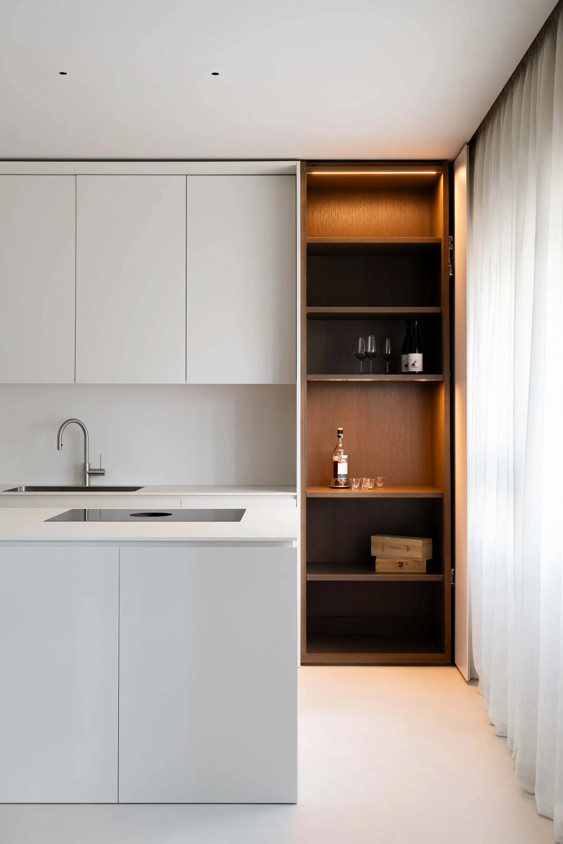 A modern minimalist kitchen with white cabinets and a sleek, contemporary design.