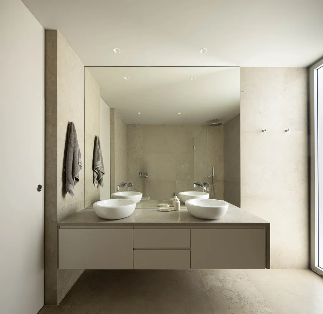 Modern minimalist bathroom interior with concrete tile walls and floor, featuring a floating vanity with two sinks and large 