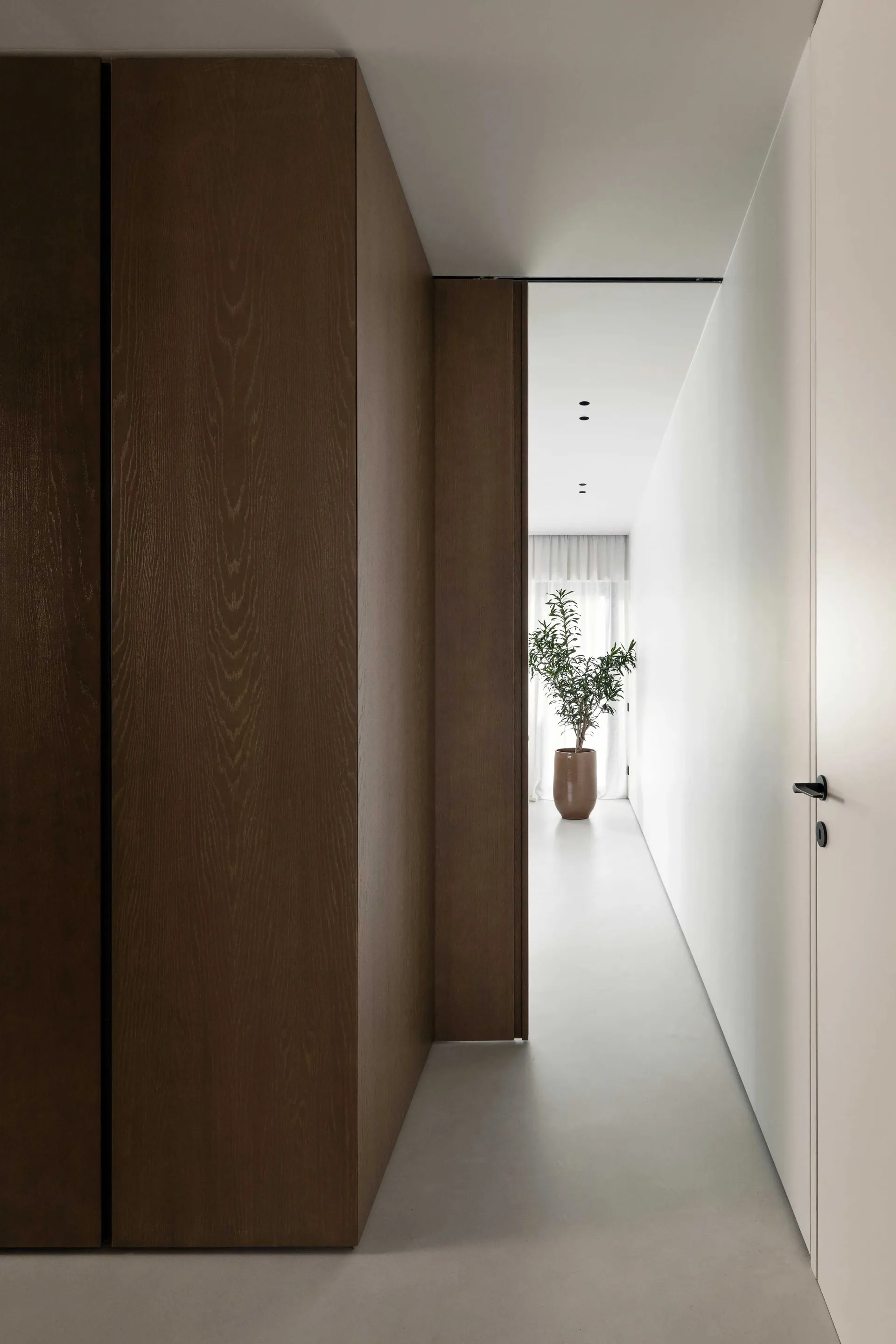 Modern interior design featuring a spacious hallway with concrete flooring.
