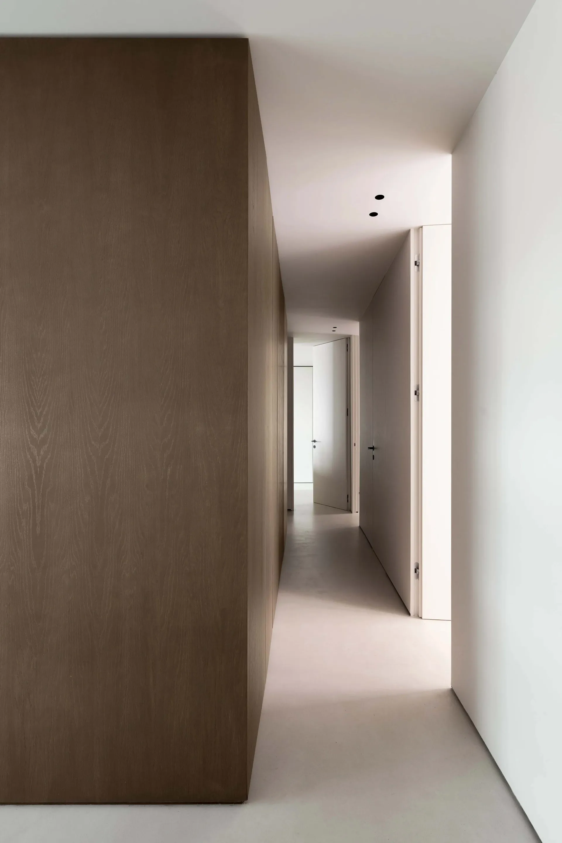 A minimalist corridor featuring concrete and wooden walls.