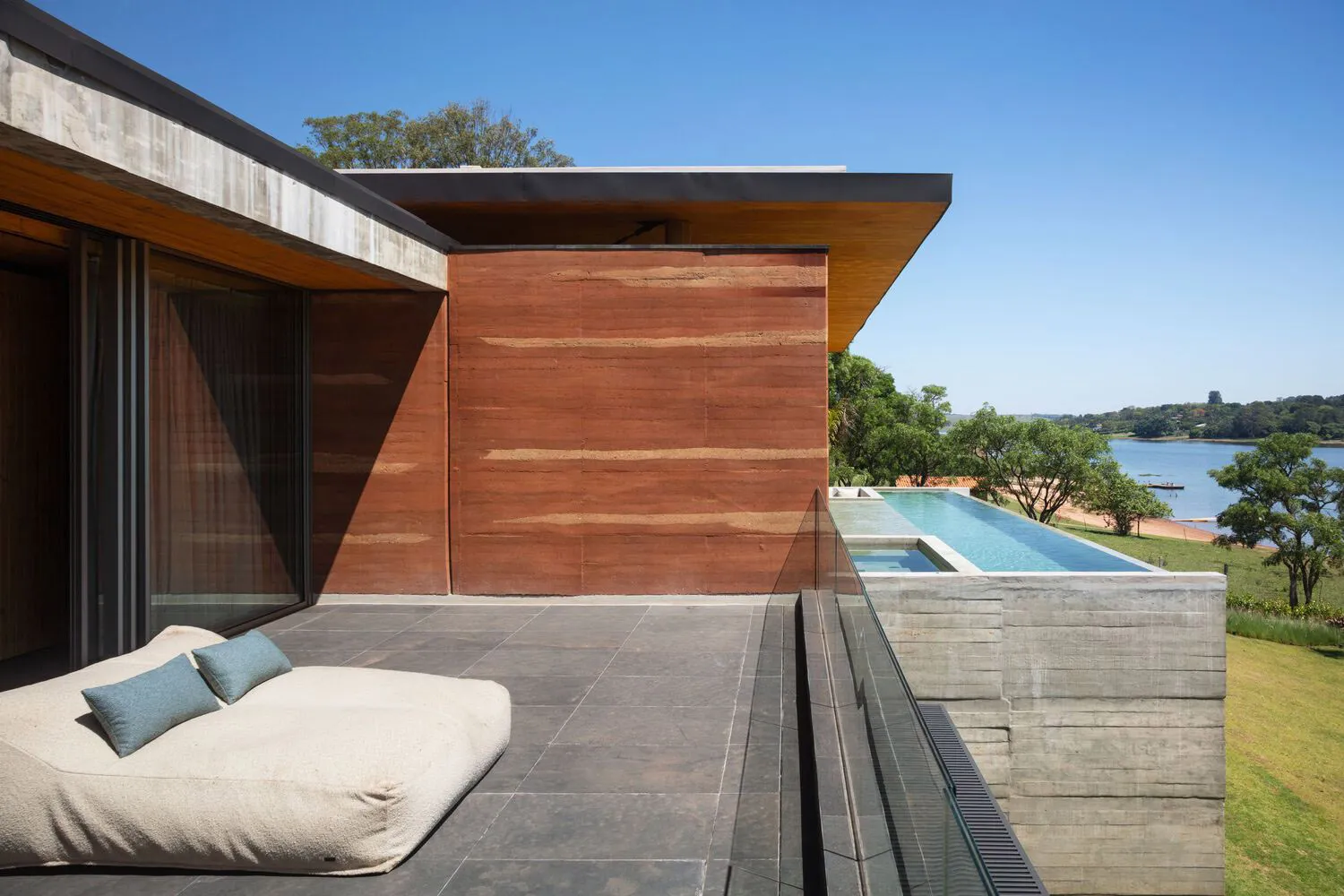 Modern, minimalist vacation home featuring a concrete exterior and wooden accents.