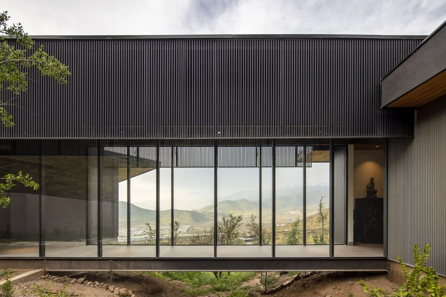 Modern house with large glass windows and black exterior cladding