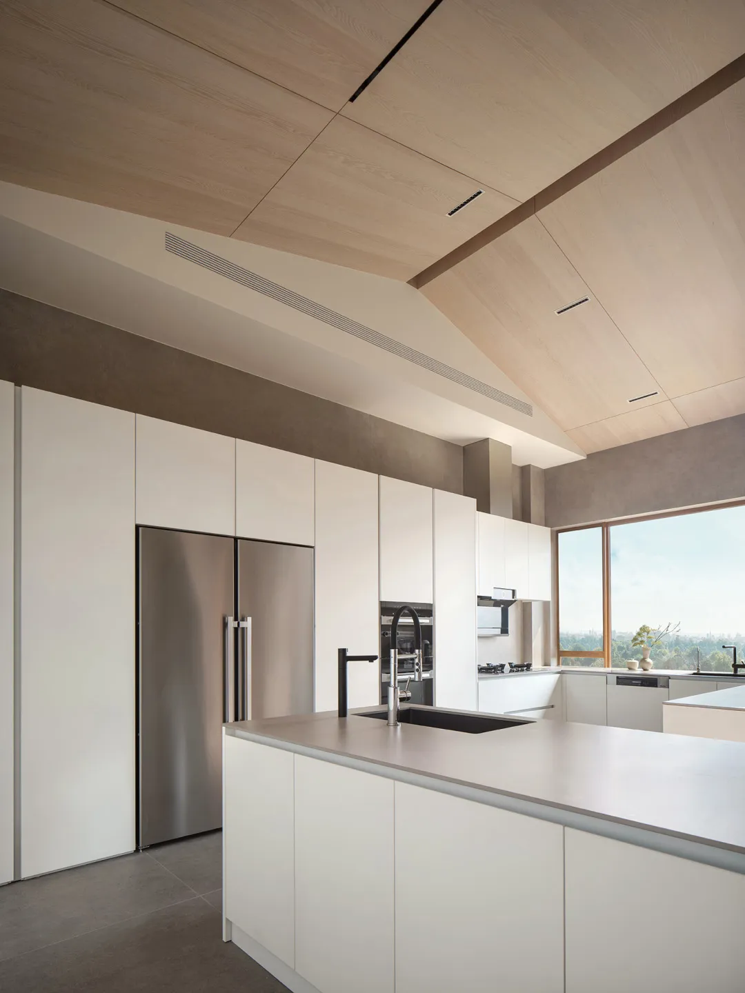 A modern minimalist kitchen featuring white cabinetry and stainless steel appliances.