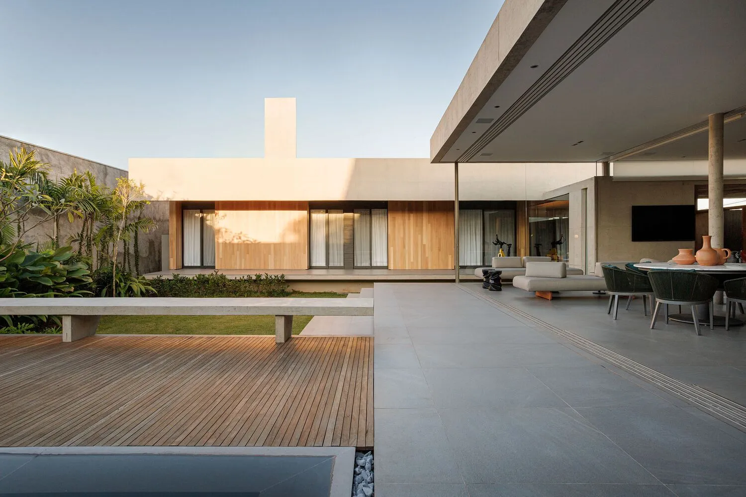 Modern residential interior designed with concrete, wood, and glass materials.