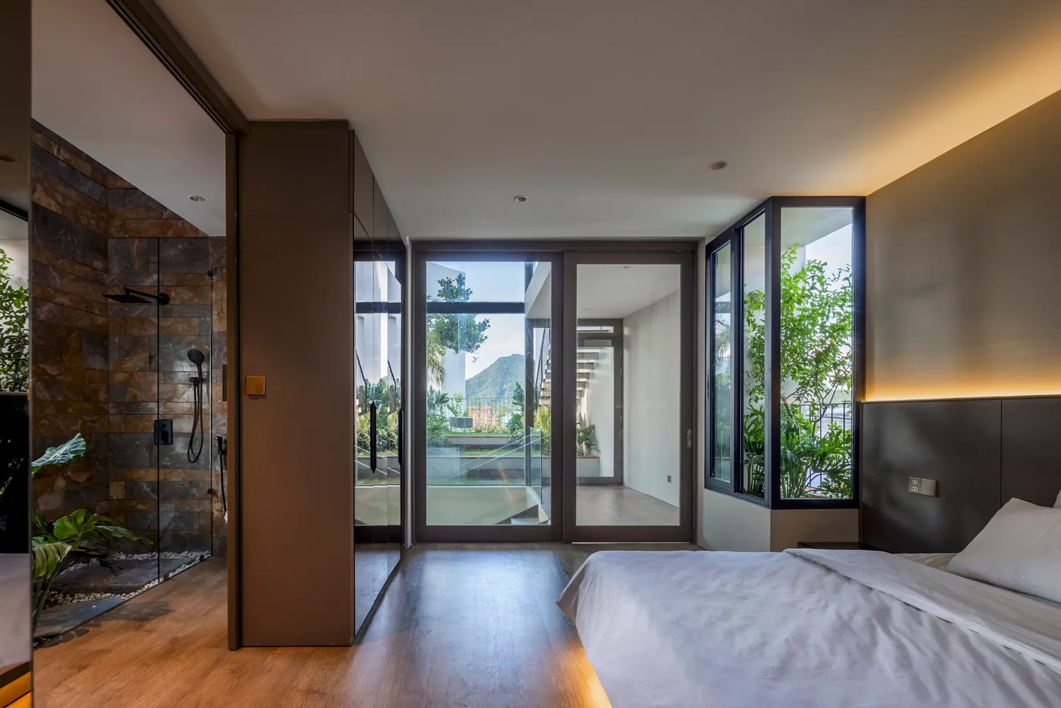 A modern residential interior with glass, wood, and stone materials.