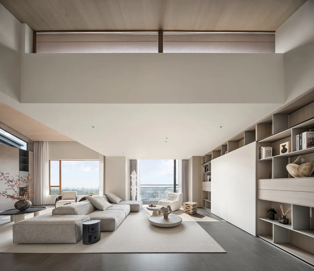 Modern minimalist living room with contemporary furniture, high ceiling, and large windows.