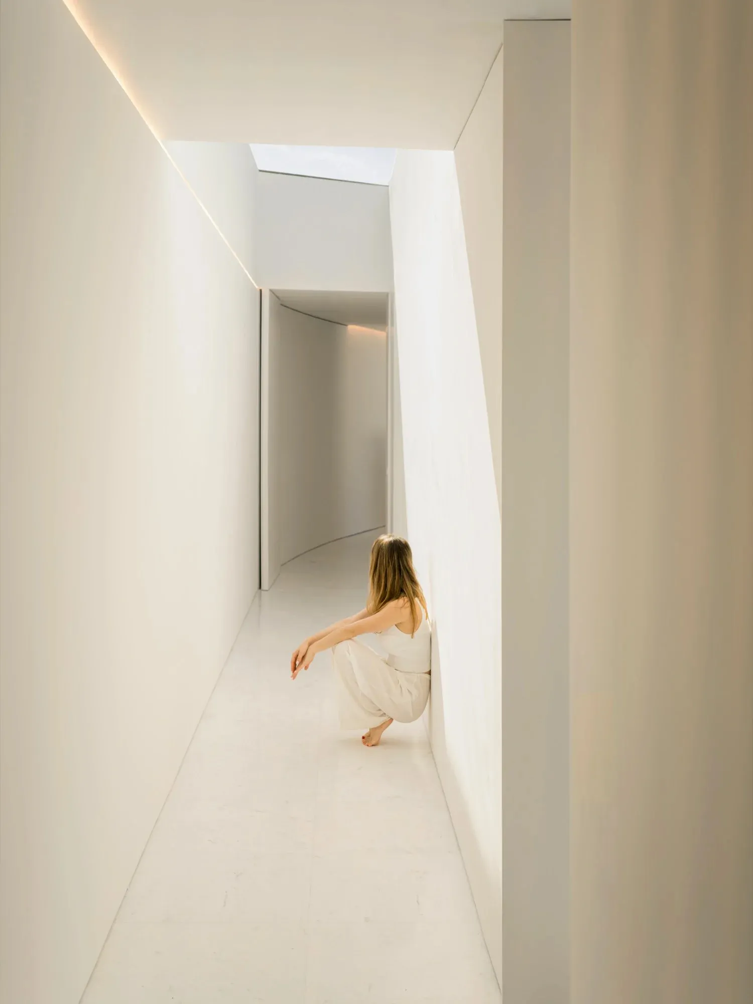 A minimalist interior space with concrete walls and floor, featuring natural light and geometric shapes.