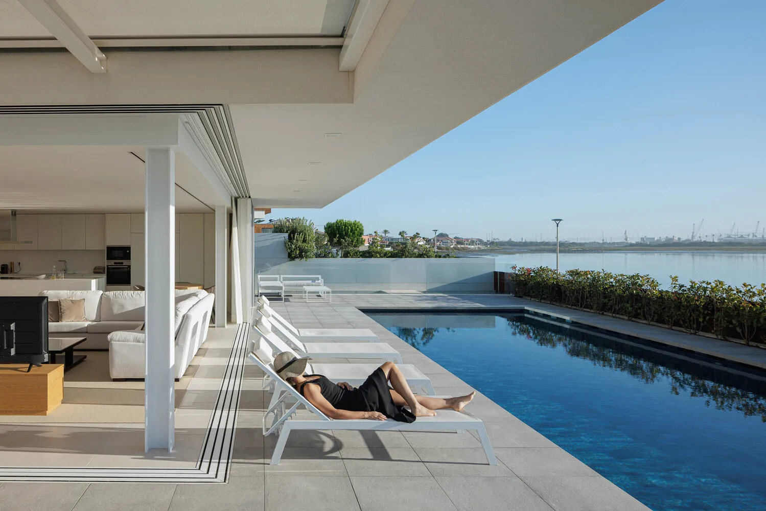 A minimalist residential patio featuring concrete flooring and glass elements.