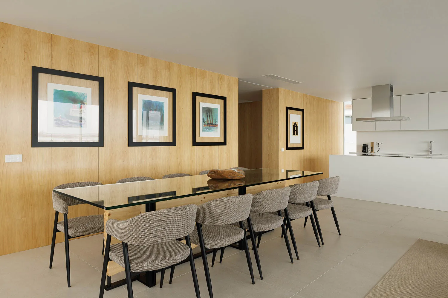 Modern dining room with glass table and wooden accents.
