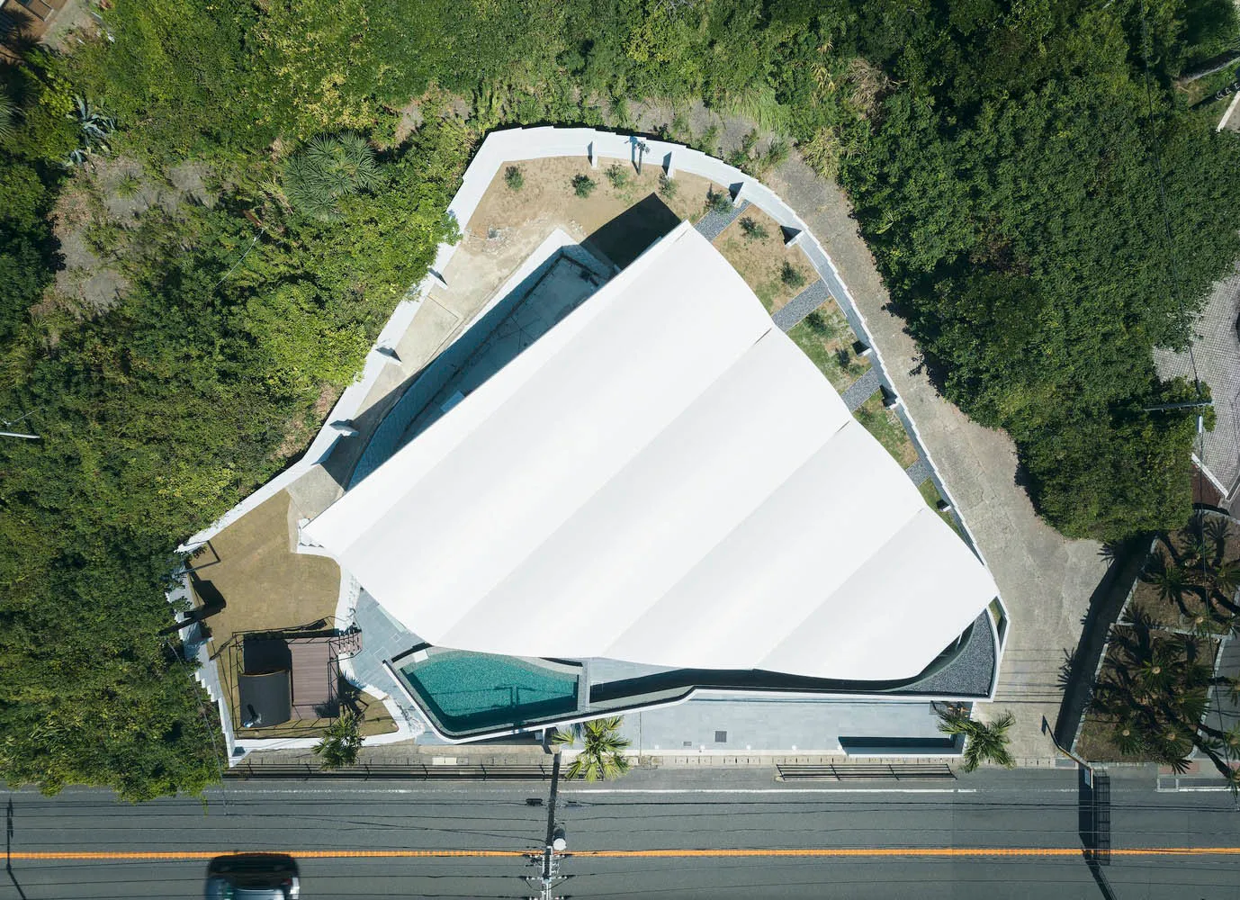 現代住宅建築,混凝土、玻璃與木質外觀,黃昏時分,露台與泳池燈光照亮。