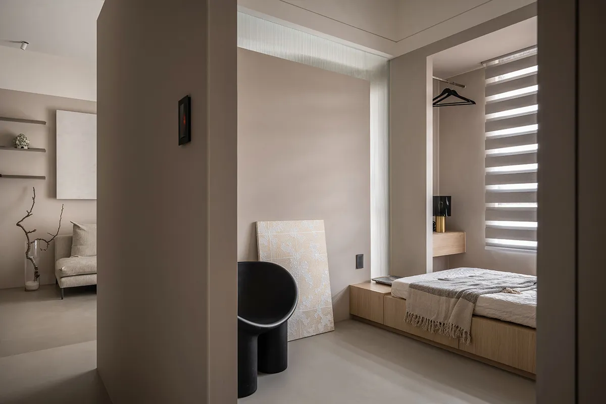 A modern minimalist bedroom featuring a wooden bed beside the bedside area.