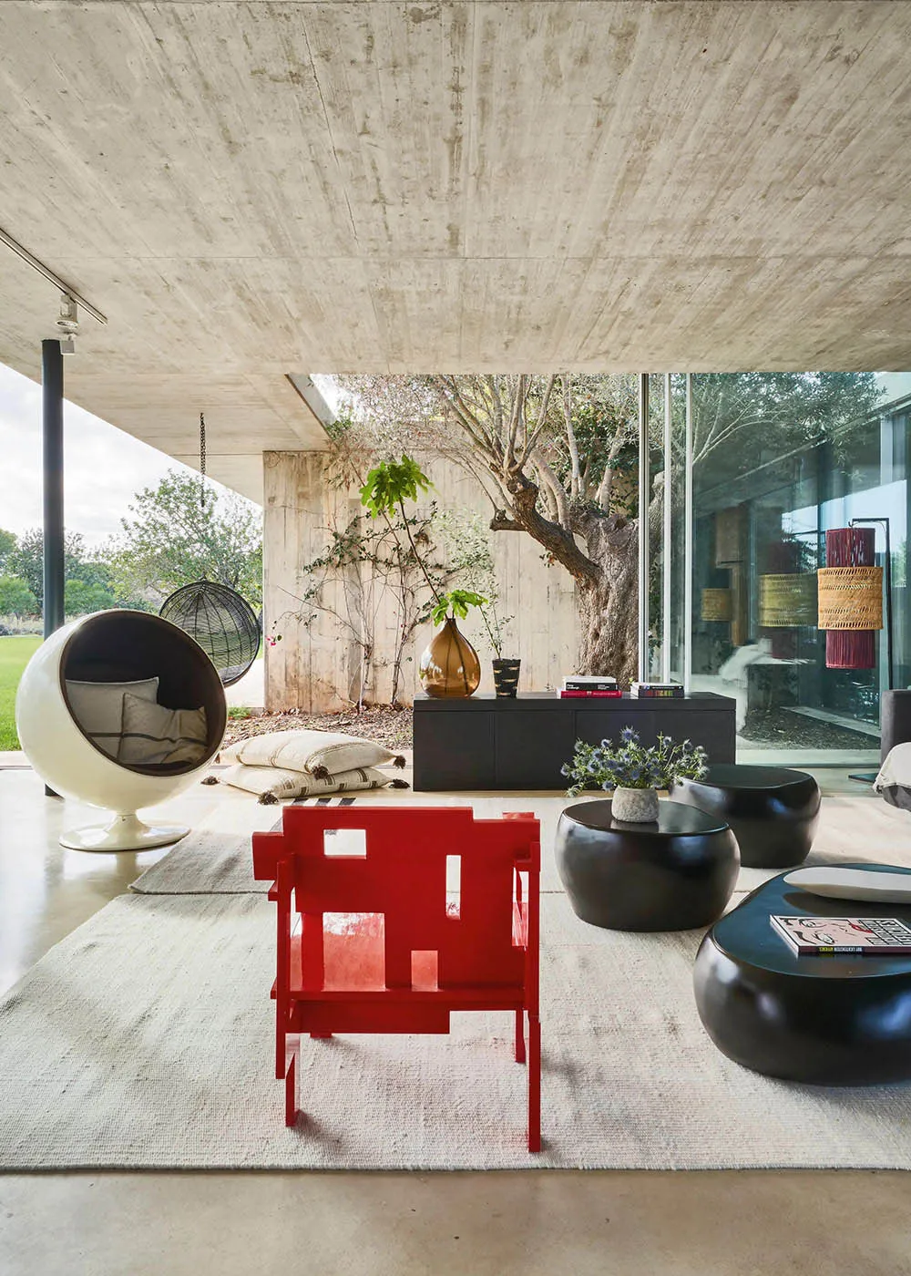 Modernist concrete living room with minimalist furniture and large windows.