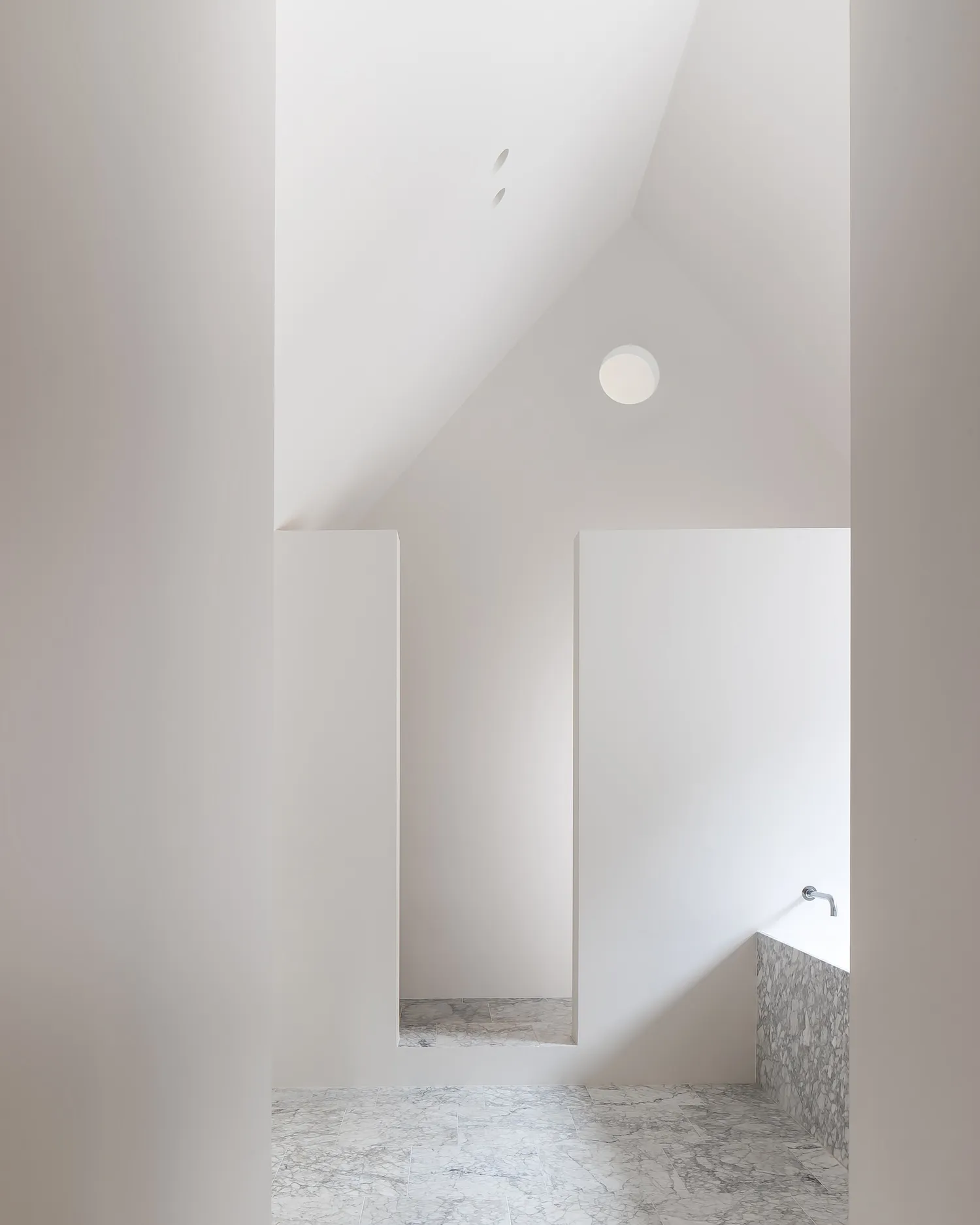 Modern minimalist bathroom with marble flooring and walls.