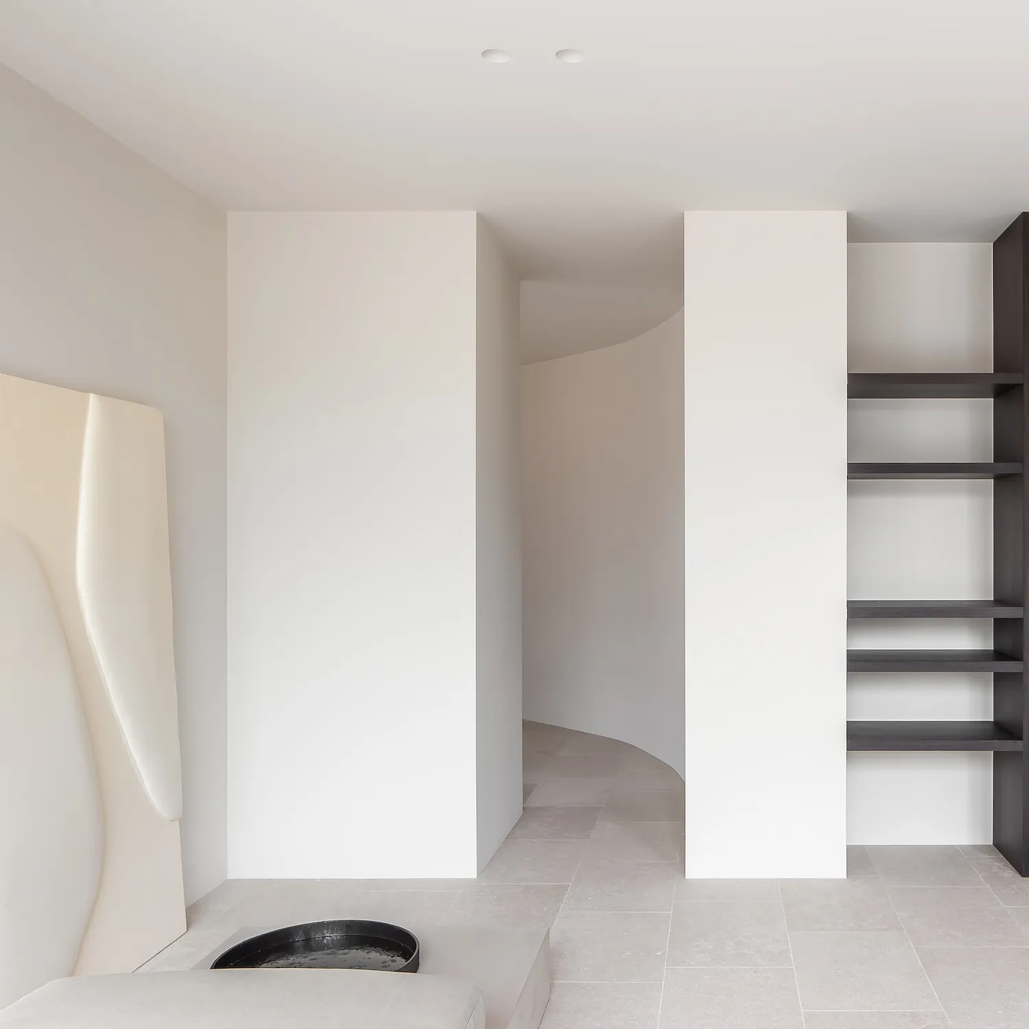A minimalist interior space featuring concrete flooring and modern architectural elements.