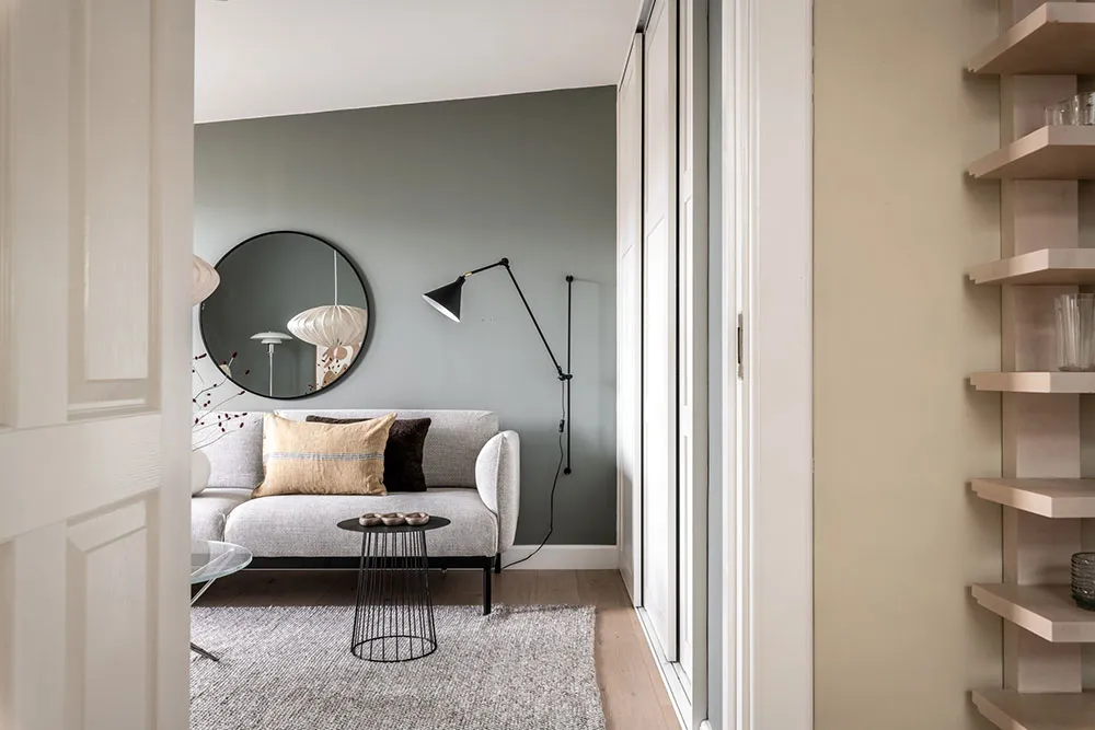 Modern minimalist living room with gray sofa, black and white scandinavian floor lamp, and minimalist coffee table.