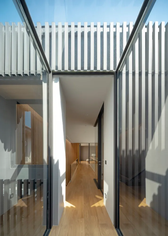 Modern architectural design featuring a glass doorway leading to an open space